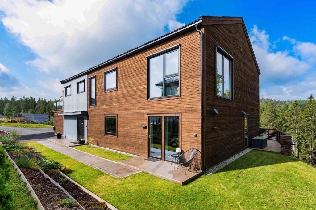 a large wooden house with a lawn at Modern apartment with two bedrooms in Hektner