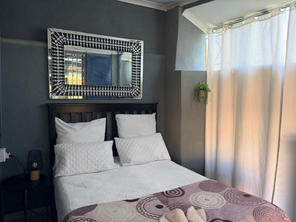 a bedroom with a bed with a mirror above it at Day&Night Stay in Johannesburg