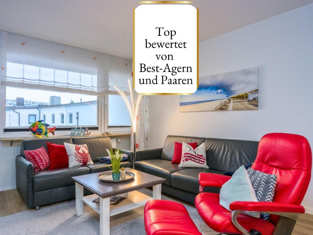 a living room with a couch and red chairs at Techt bi Strön 4 Sterne TOP-Fewo 2 WC Sauna Balkon Strand 5 Min Zentrum in Westerland