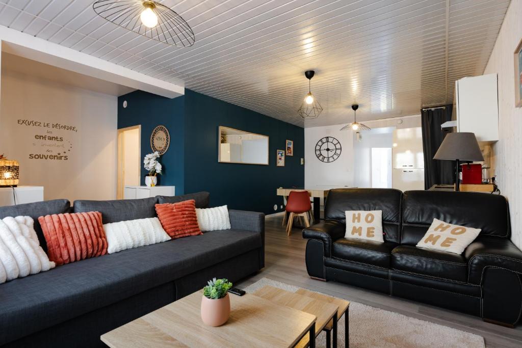 a living room with a couch and a table at Le Reflet des Pyrénées in Bagnères-de-Bigorre
