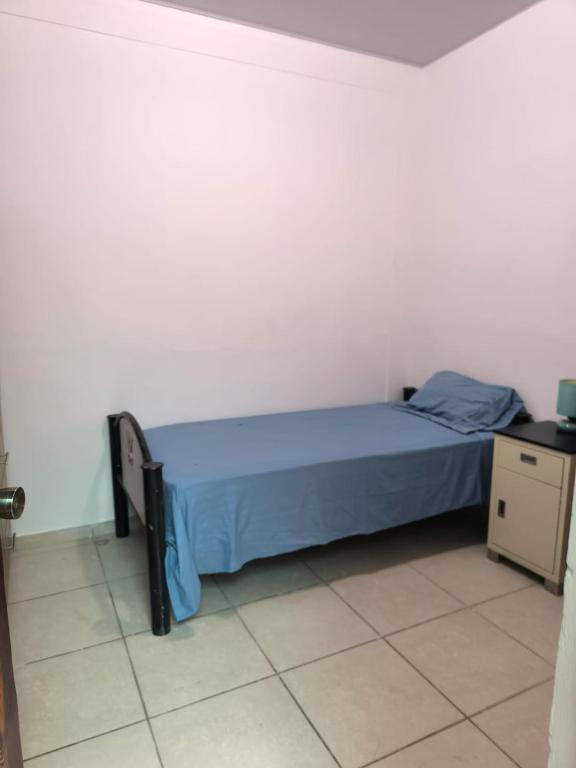 a bedroom with a bed with a blue bedspread at Marbyn & Ana House in Tegucigalpa