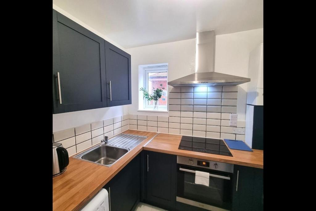 a kitchen with a sink and a stove at Peace Guest House in Hoo