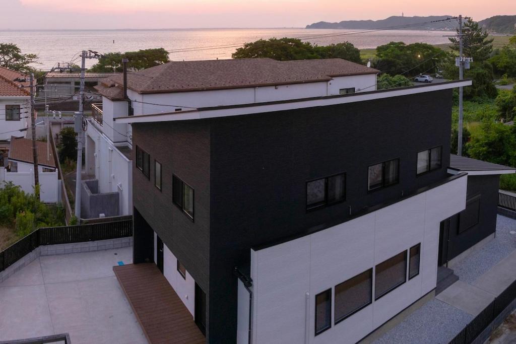 a black and white building with a view of the ocean at Links Seaside resort in Futtsu