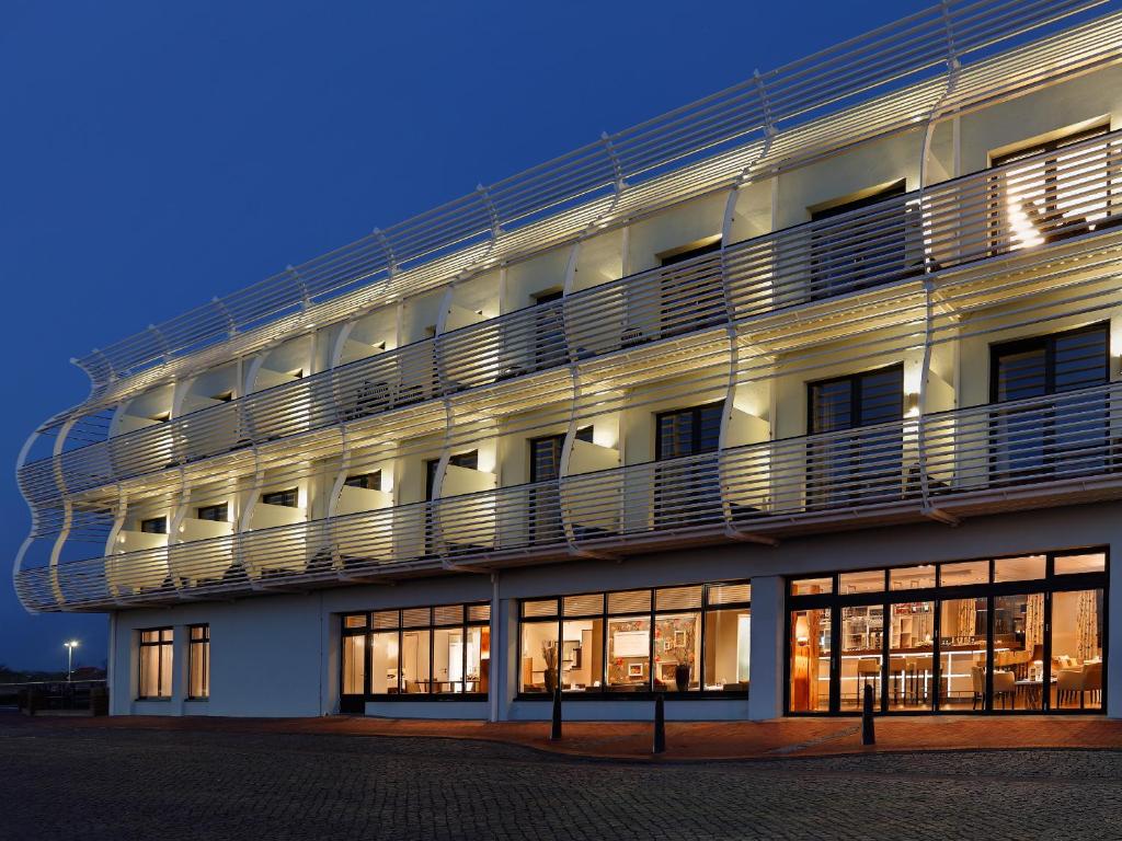 un gran edificio blanco con balcones en un lateral. en Hotel Fährhaus, en Norddeich