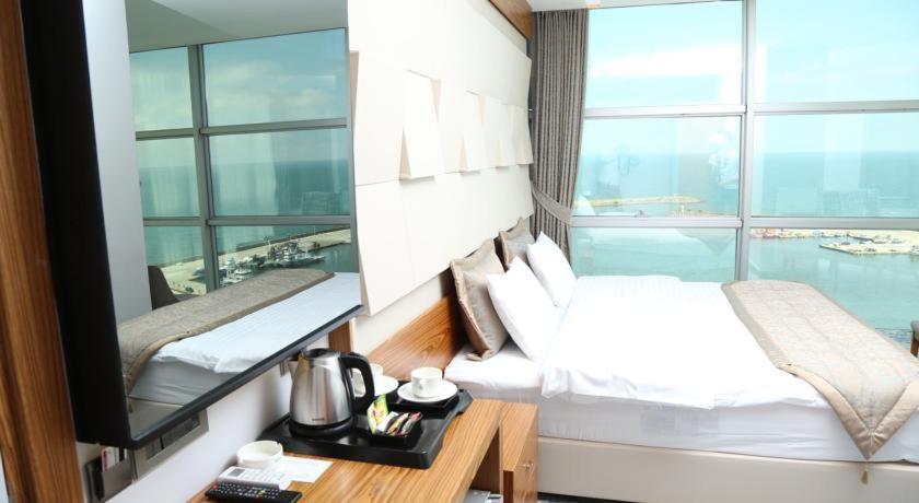a hotel room with two beds and a large window at Panorama Damla Otel in Samsun
