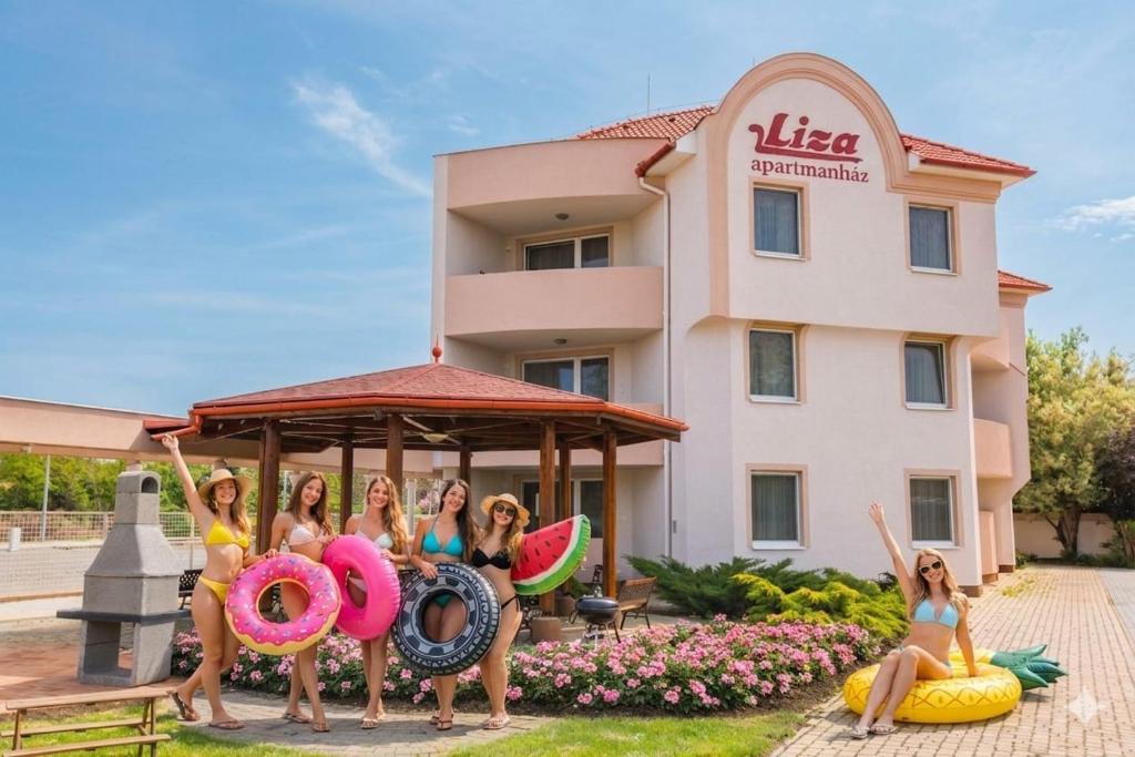 a group of girls posing in front of a hotel with giant donuts at Liza Apartmanok in Hajdúszoboszló