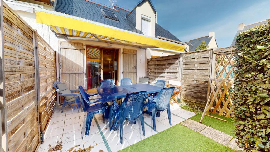 a patio with a blue table and chairs and a fence at La Maison du Carbonet in Batz-sur-Mer