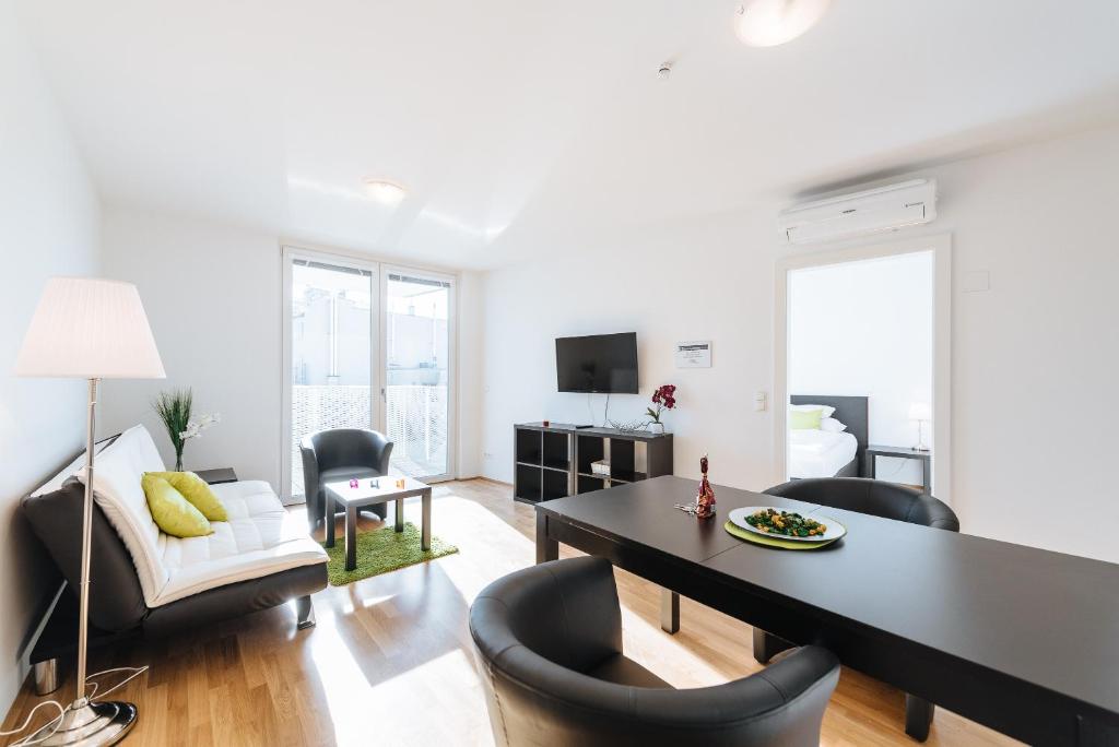 a living room with a dining room table and chairs at Duschel Apartments Wien-Hauptbahnhof in Vienna