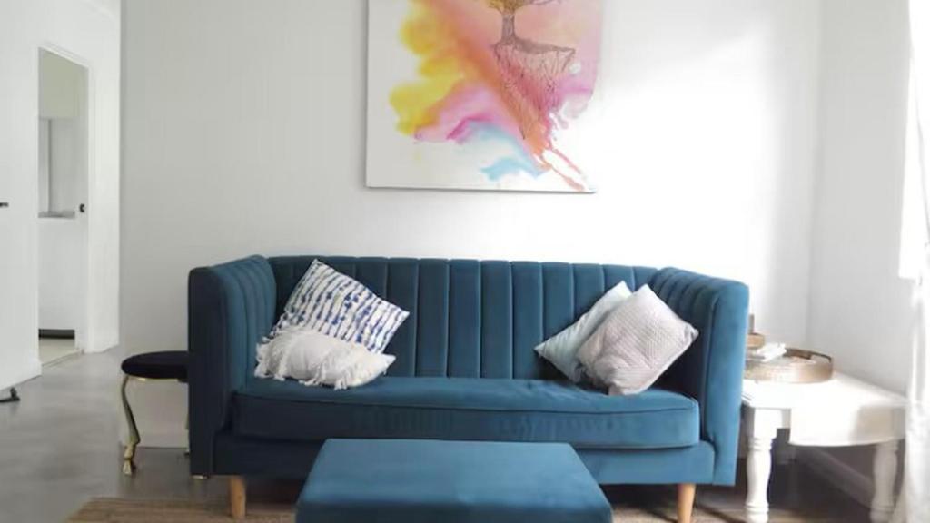 a blue couch with pillows in a living room at Stylish Coastal Stay in Cronulla