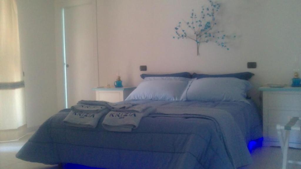 Sant' IsidoroにあるChalet delle roseのベッドルーム1室(青いベッド1台、木の壁付)