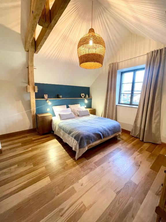 a bedroom with a bed and a large window at La Villa de Paul - Les Chambres in Yenne