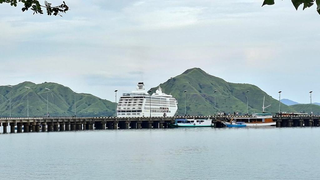 a cruise ship is docked next to a pier at LA Komodo Homestay in Komodo