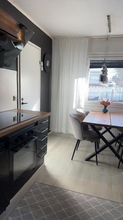 a kitchen with a table and a dining room at Rubin Apartment - moderni huoneisto lähellä keskustaa in Kajaani