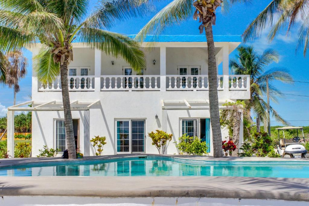 a house with a swimming pool and palm trees at View the Blue in San Pedro