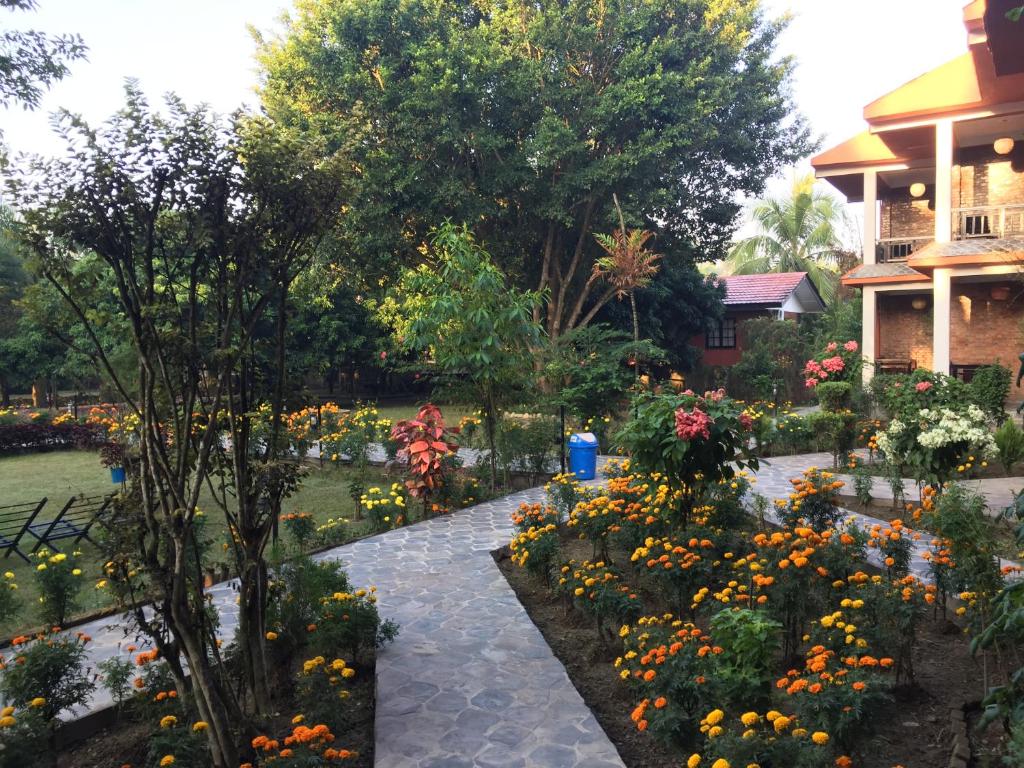 a garden of flowers in front of a house at Chautari Garden Resort in Sauraha