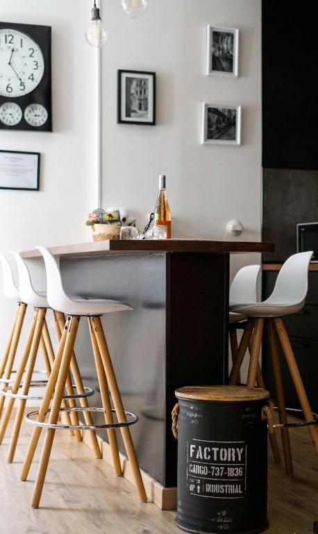 a kitchen with a bar with stools and a clock on the wall at Cocon cosy hyper-centre idéal 4 personnes in Tours