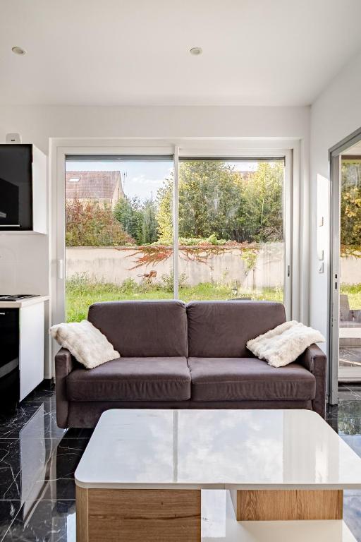 a living room with a couch and a large window at Loft design climatisé in Thiais