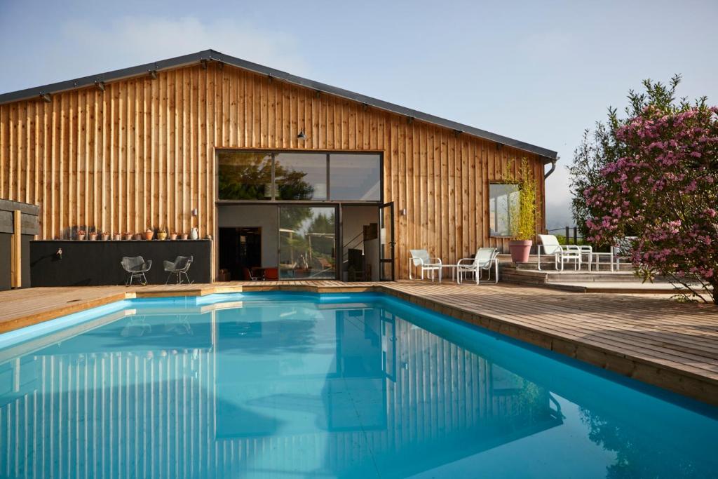 a house with a swimming pool in front of a building at Domaine Aari Ona in Aramits