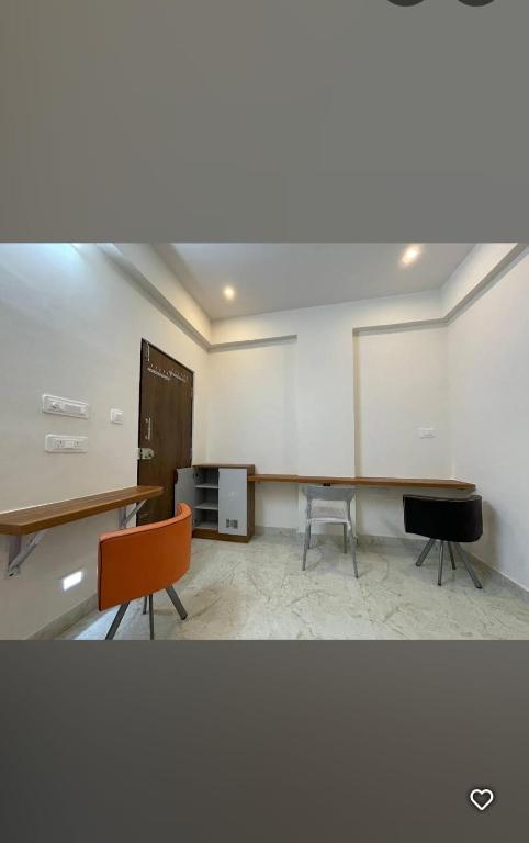 a room with a table and two chairs and a chalkboard at Sanvi studio rooms in Bangalore