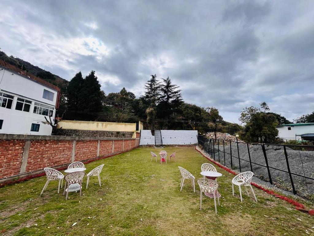 a group of chairs sitting on the grass in a yard at Banj View Resort in Mussoorie