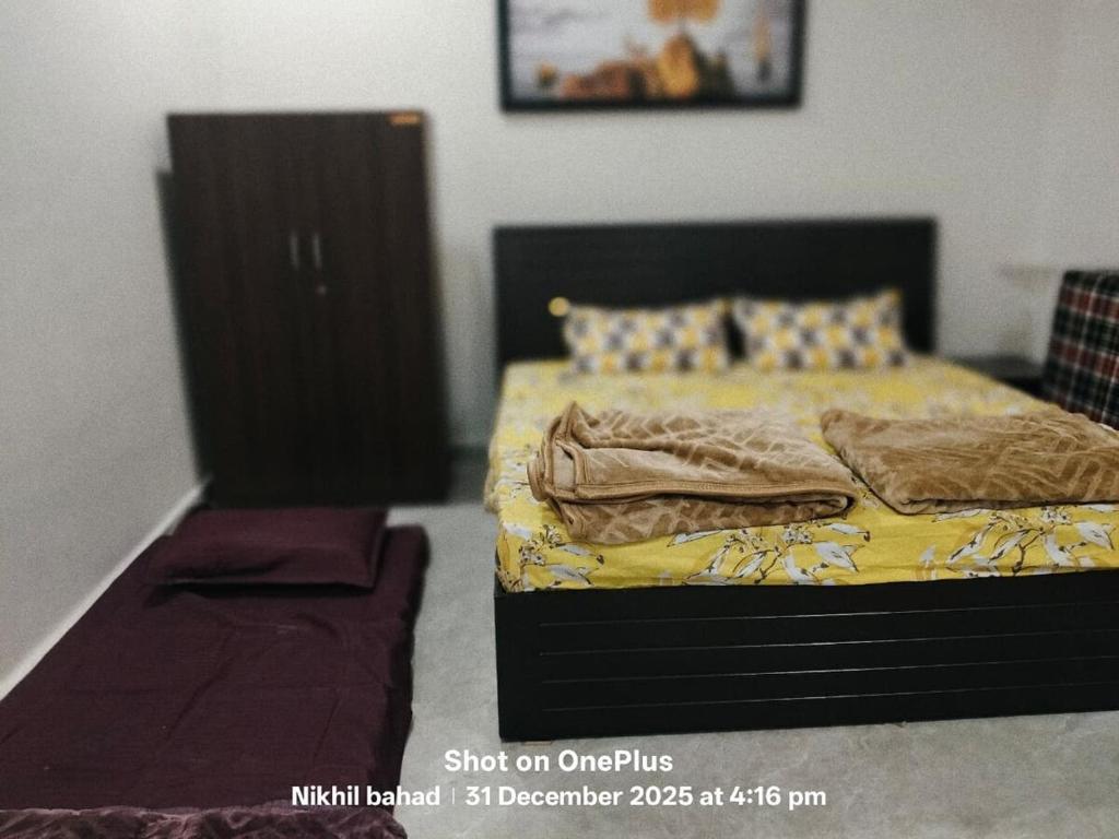 a bedroom with a bed with yellow sheets and pillows at aasara resort in Bhopal