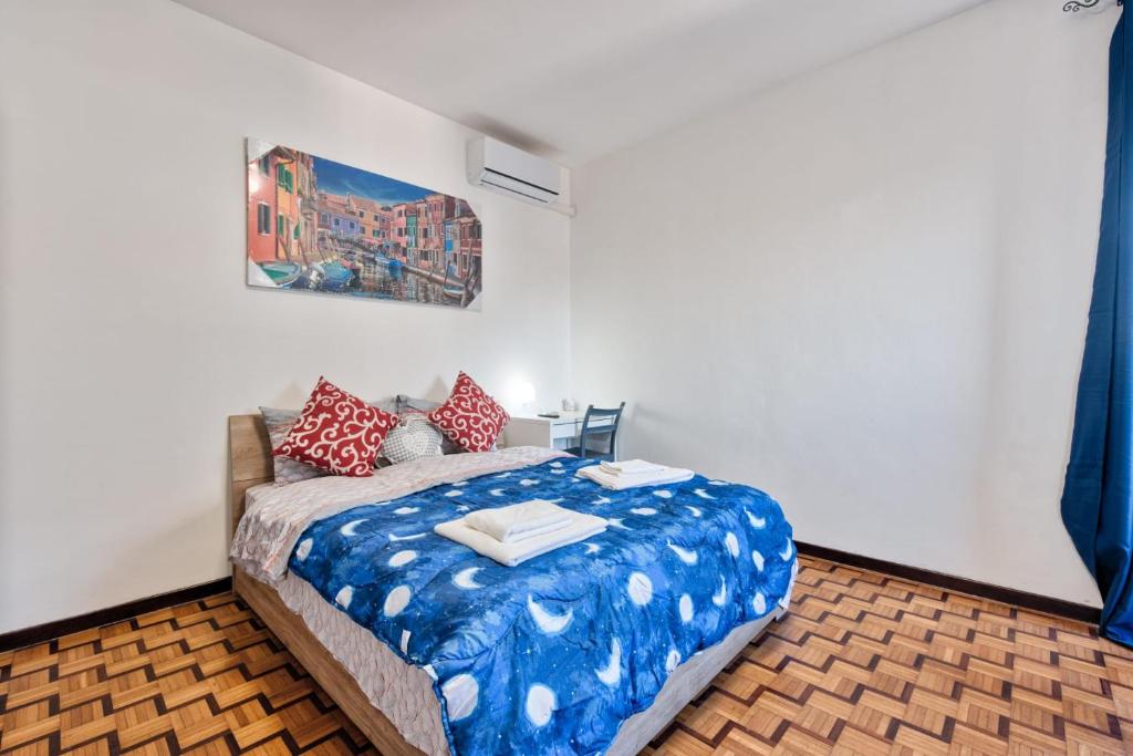 a bedroom with a bed with blue and red pillows at Easy Downtown Inn in Marghera