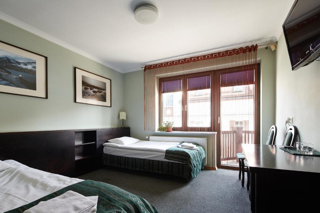 a hotel room with a bed and a window at Willa Pierrot in Oświęcim