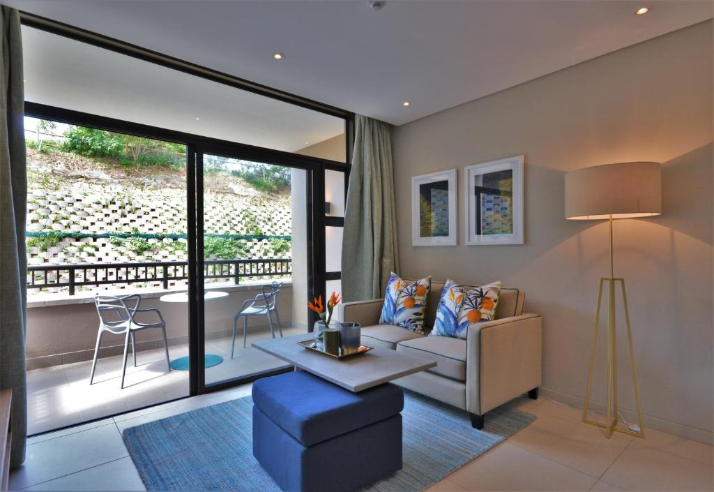 een woonkamer met een bank en een tafel bij 418 Zimbali Suites in Ballito