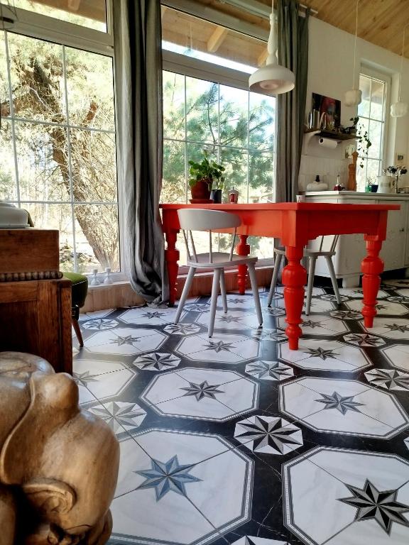 a dining room with a red table and stars on the floor at Ulęgałki Roztocze Stodoła in Jacnia
