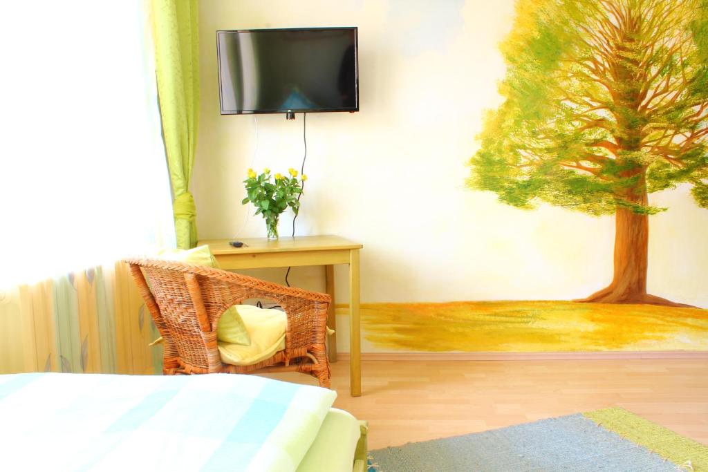 a bedroom with a tv and a tree on the wall at Kessenbrock Appartements in Witten