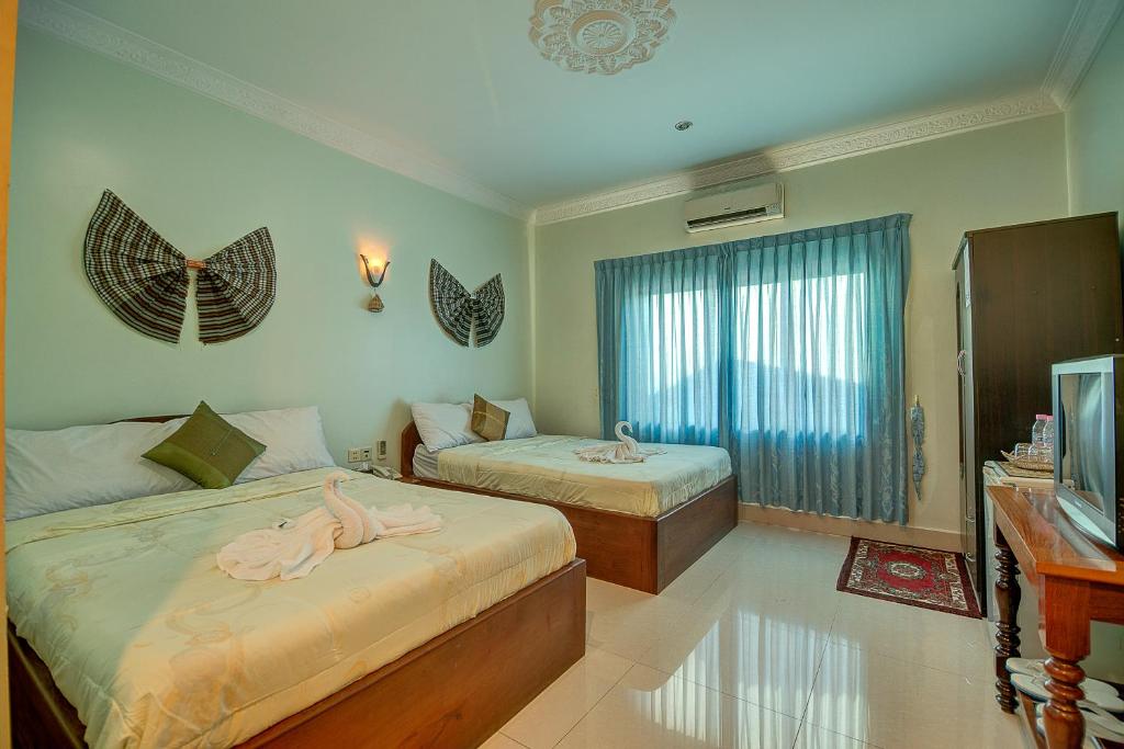 Postel nebo postele na pokoji v ubytování DV Angkor Villa