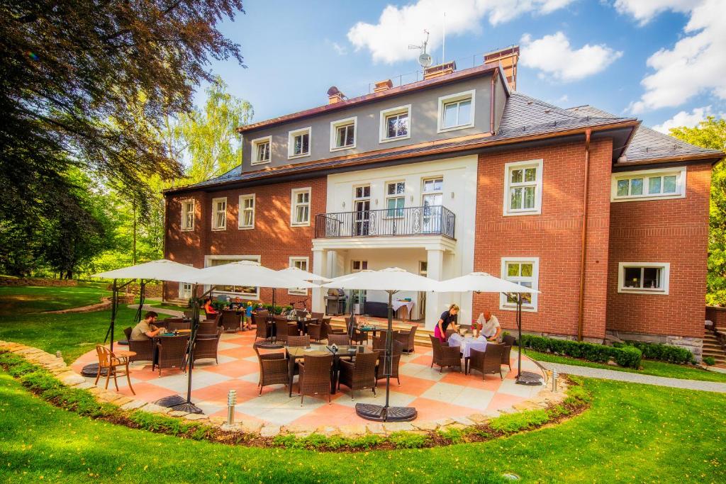 Leute, die auf einer Terrasse vor einem Gebäude sitzen in der Unterkunft Manor House in Broumov