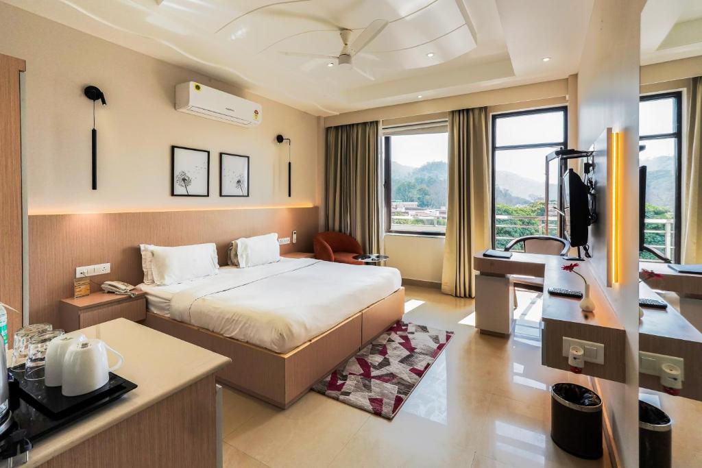 a hotel room with a bed and a desk at Hotel Yog Vashishth in Rishīkesh