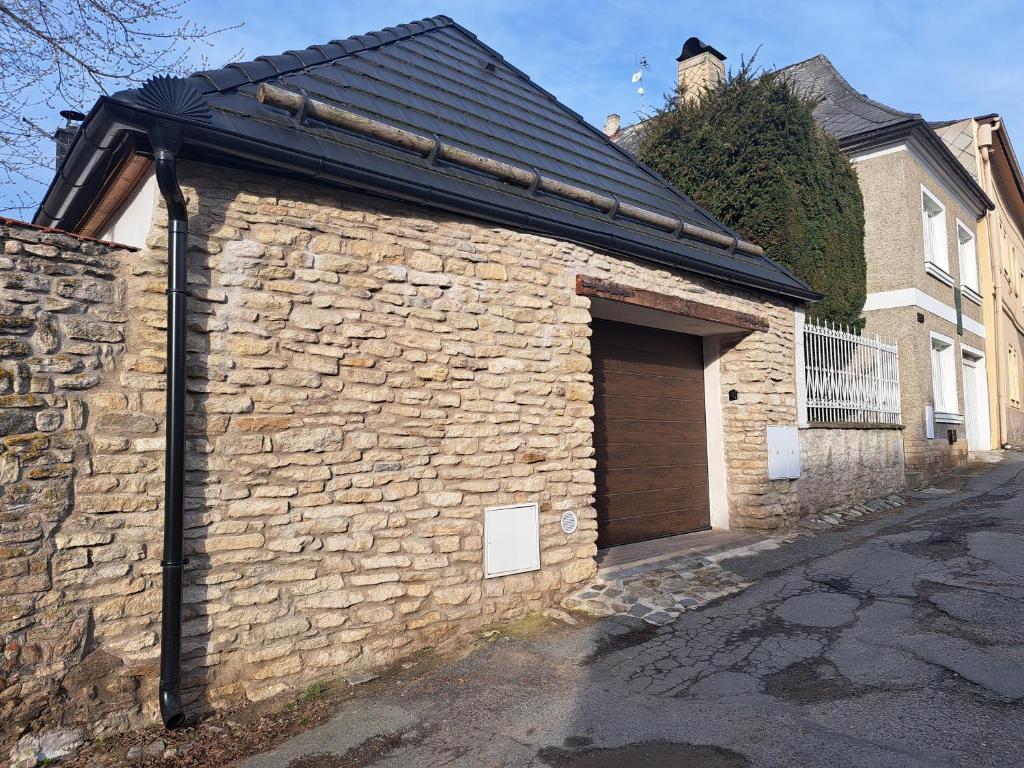a brick building with a door and a garage at Pension Garage in Kutná Hora