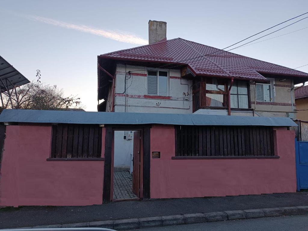 a red and white house with a blue roof at Casa ANDA in Braşov
