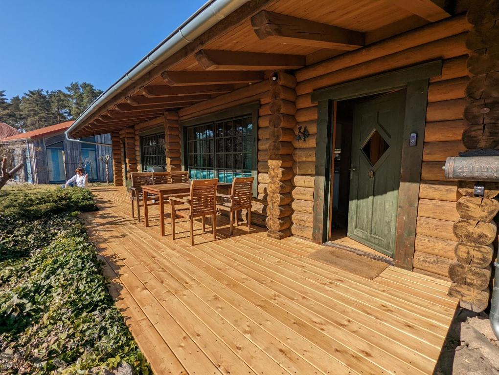 a wooden deck with a table and chairs on a cabin at Blockhaus Fleesensee in Silz