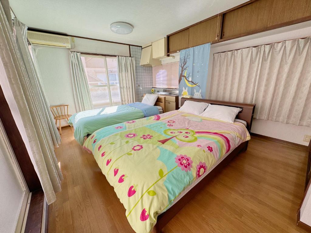 a bedroom with a bed with a floral bedspread at 別府ホーム in Beppu
