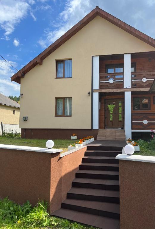 a house with a staircase leading to the front door at У Блищака in Pilipets
