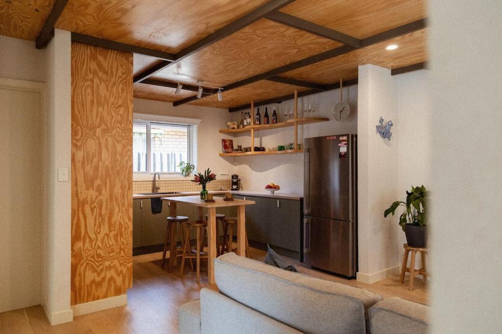 a kitchen with a couch and a table and a refrigerator at Kodok House in Melbourne