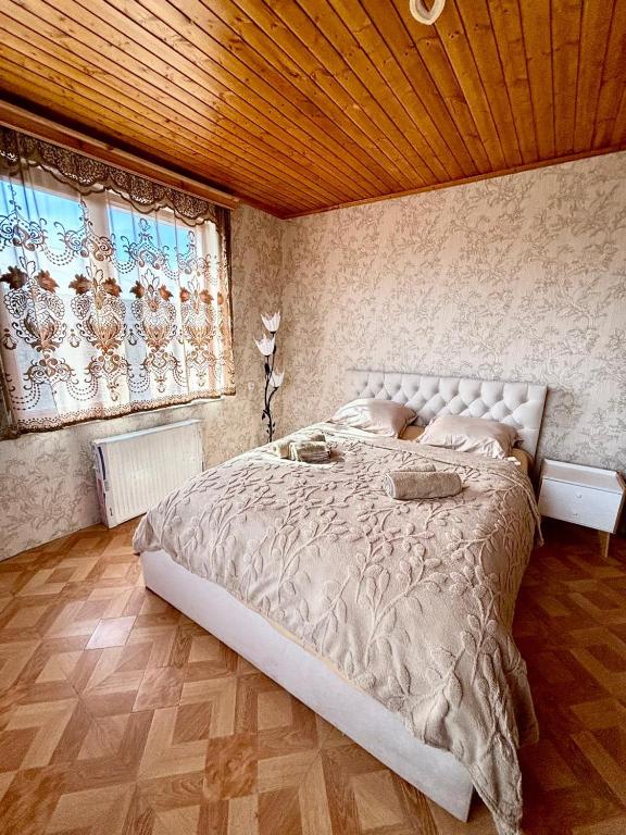 a bedroom with a large bed and a window at Guesthouse IMEDI in Velistsʼikhe