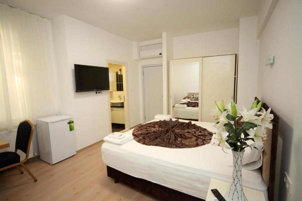 イスタンブールにあるBeyazköşk Otelの花瓶付きの大きなベッドが備わるベッドルーム1室が備わります。