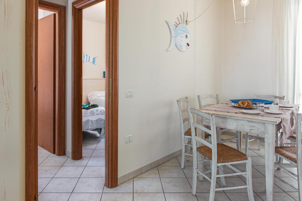 a dining room with a table and chairs and a mirror at Villetta Tina in Vada