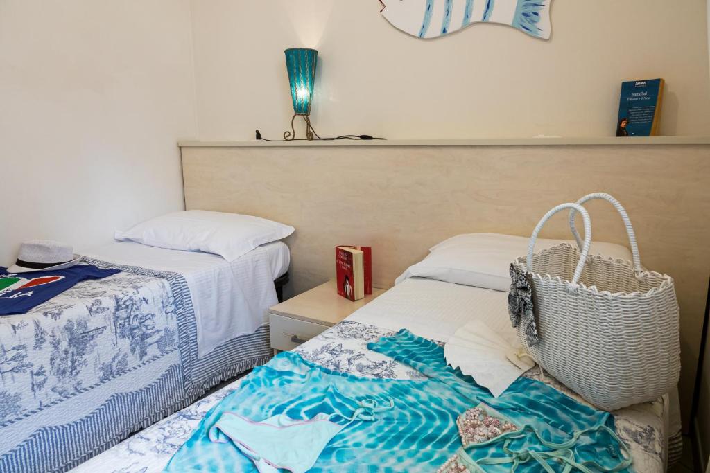 a bedroom with two beds and a basket on the bed at Villetta Tina in Vada