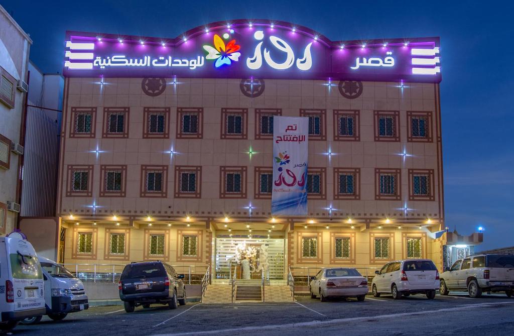 un grande edificio con macchine parcheggiate di fronte di Rose Palace For Residential Units a Abha