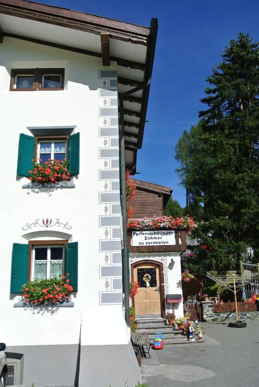 a white building with flower boxes on the windows at Pension Hof zur Stilli in Davos