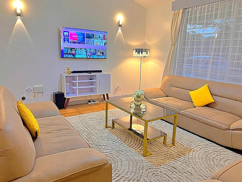a living room with a couch and a table at Luxury 4 BR Homely Apt with a pool in Kisumu