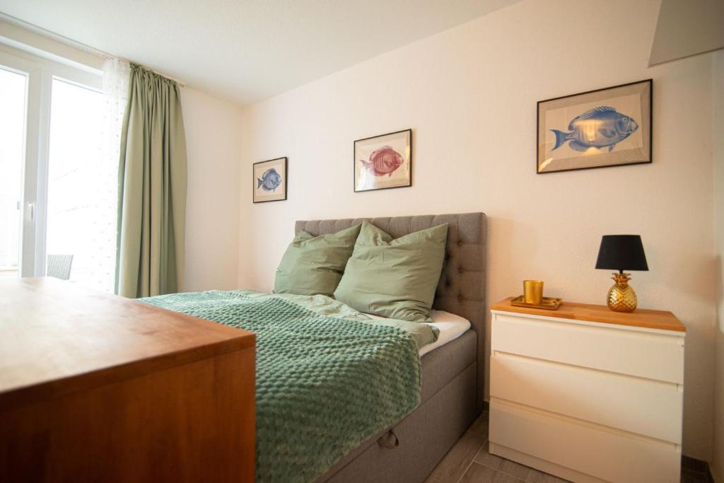 a bedroom with a bed with a green comforter at Appartement eleven in Duisburg