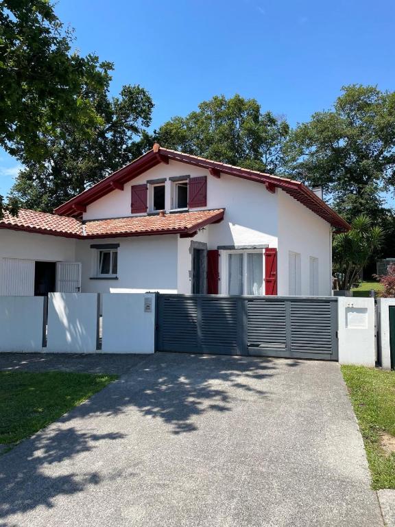 a white house with a fence and a driveway at Maison familiale in Bidart