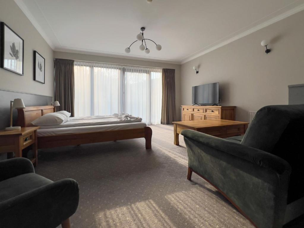 a bedroom with a bed and a couch and a tv at Willa 654 in Szklarska Poręba