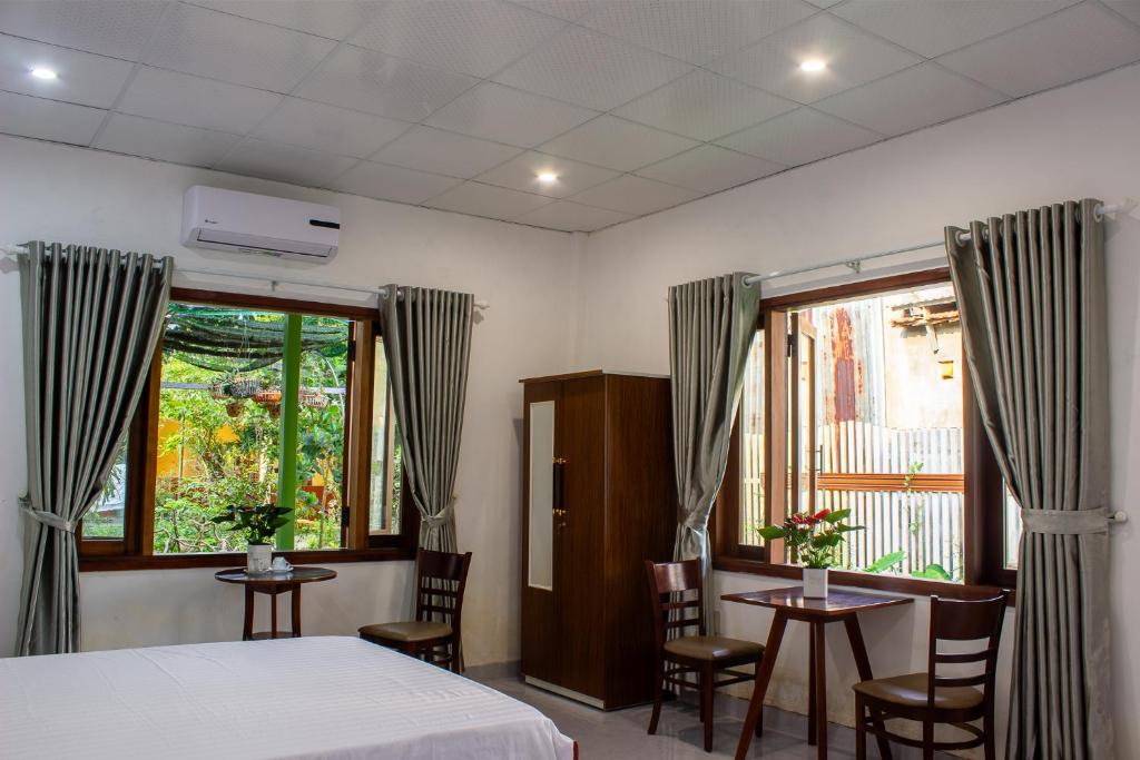 a bedroom with a bed and two tables and chairs at Hue garden homestay in Thôn Trường Giang